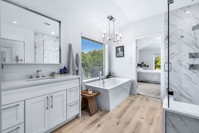 Ensuite bathroom featuring a soaking tub, a marble finish shower, a chandelier, and double vanities | Image 25