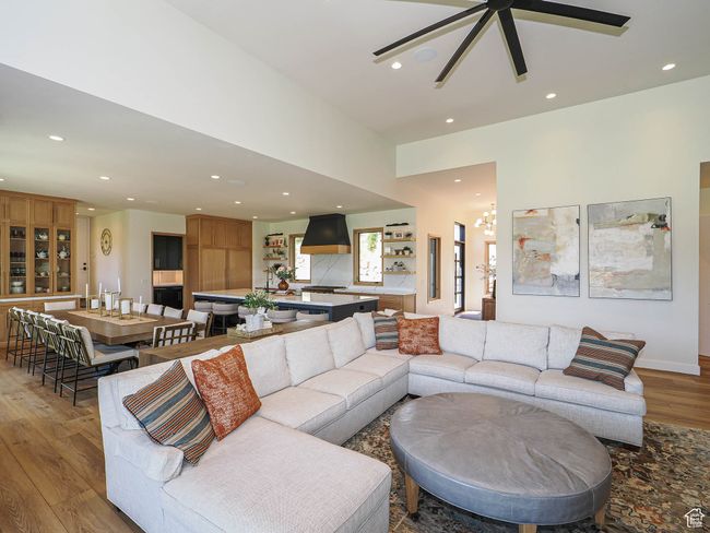Living area featuring light wood-style floors, recessed lighting, ceiling fan, and a chandelier | Image 28