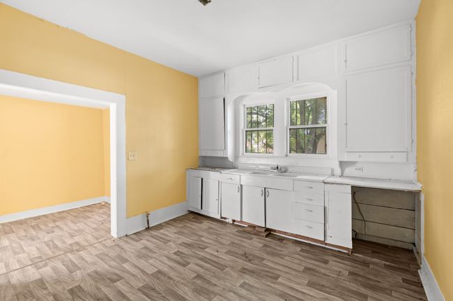Kitchen featuring white cabinetry, light countertops, and light wood finished floors | Image 6