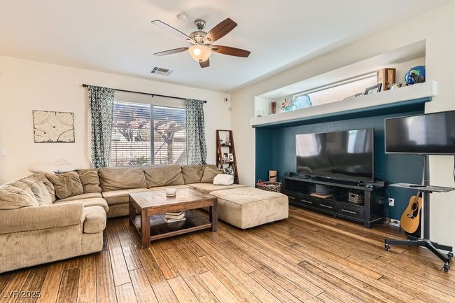 Living room with visible vents, wood finished floors, and a ceiling fan | Image 6