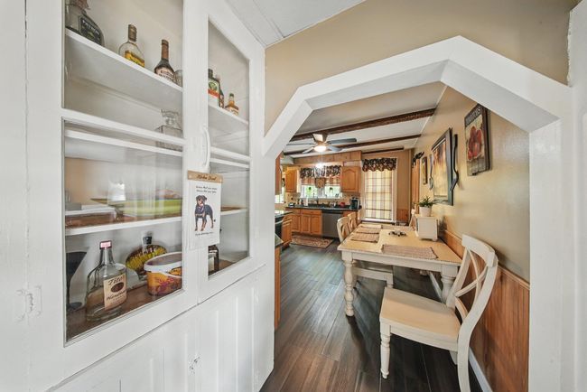 Dining area featuring ceiling fan, dark wood-style flooring, and beam ceiling | Image 13