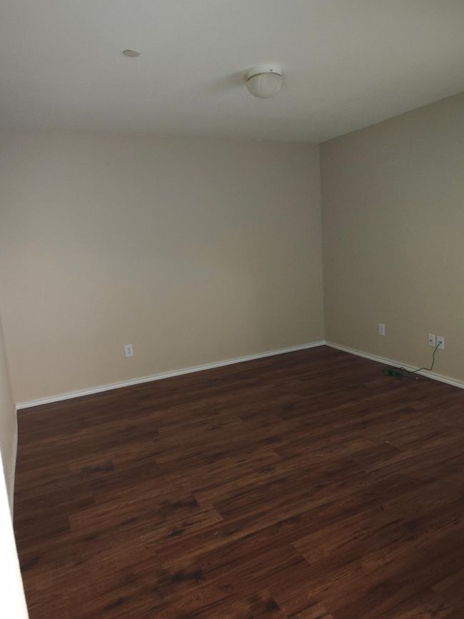 Spare room with dark wood-style flooring and baseboards | Image 8