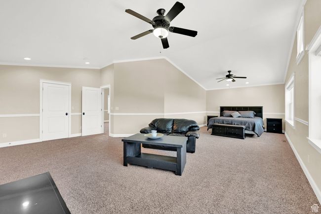 Living room with ornamental molding, carpet flooring, vaulted ceiling, and ceiling fan | Image 49