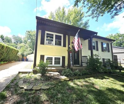 View of front of property featuring a garage and a front lawn | Image 1