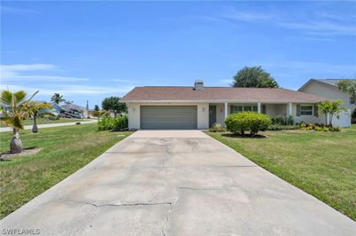 Ranch-style house featuring a garage and a front yard | Image 2