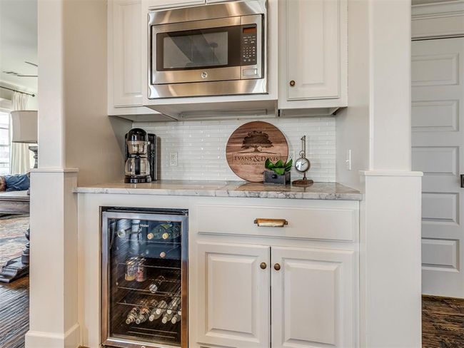 Bar featuring beverage cooler, stainless steel microwave, and backsplash | Image 7