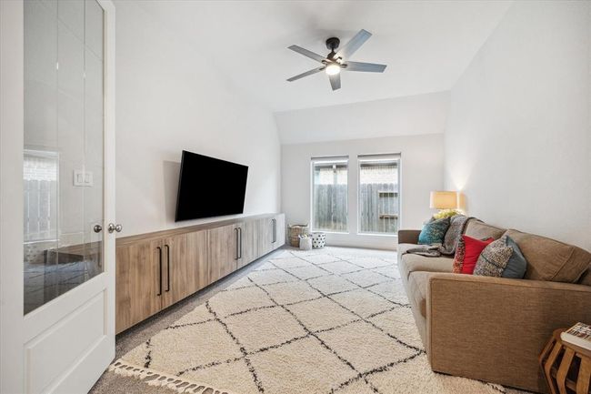 Gracefully positioned off the foyer, this versatile flex space features French doors and custom built-in cabinetry, offering an elegant setting for an additional home office, music room, or entertainment area. | Image 4