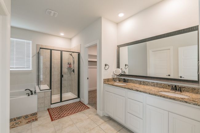 Full bath with double vanity, a stall shower, a sink, tile patterned floors, and a bath | Image 29
