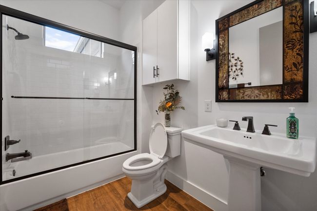 Full bathroom with enclosed tub / shower combo and pedestal sink. | Image 19