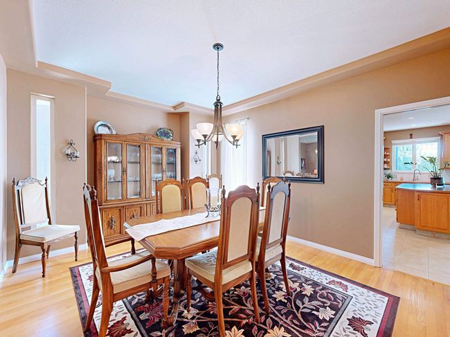 Dining area featuring a chandelier, light wood-style flooring, and a raised ceiling | Image 15