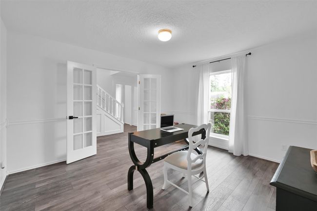 To the left of the Foyer is the Study overlooking the beautiful front yard with glass panel French doors and wood laminate flooring. Located at the front of the home, this room provides quiet and privacy. | Image 4