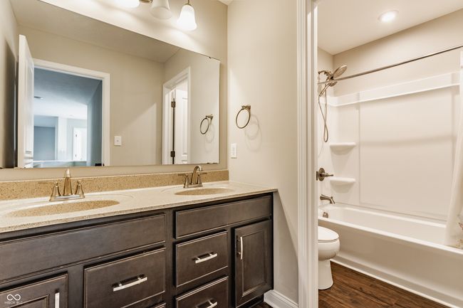 full bath featuring wood finished floors, a sink, double vanity, and toilet | Image 35