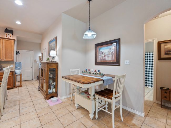 Dining room with light tile patterned floors, arched walkways, recessed lighting, and baseboards | Image 11