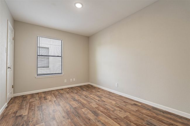 Upstairs bedroom with wood-look flooring, neutral tones, and natural light — a cozy and quiet place to unwind. | Image 10