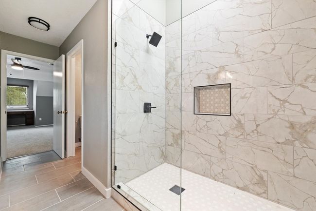 Bathroom featuring tiled shower, baseboards, and a ceiling fan | Image 8