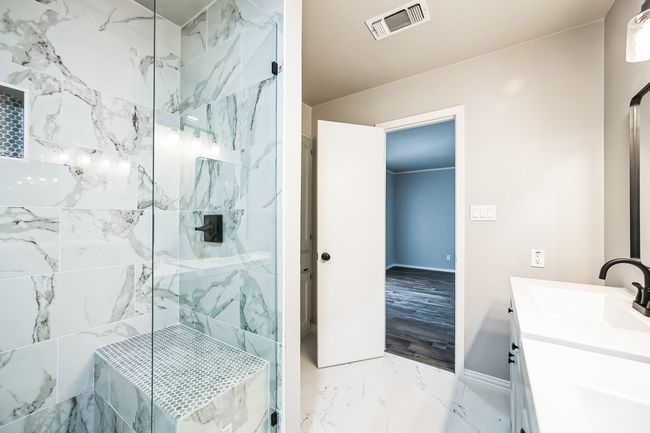 Full bath featuring vanity, baseboards, a marble finish shower, visible vents, and marble finish floor | Image 9