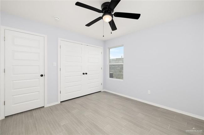 Unfurnished bedroom with baseboards, a closet, light wood-style flooring, and ceiling fan | Image 9