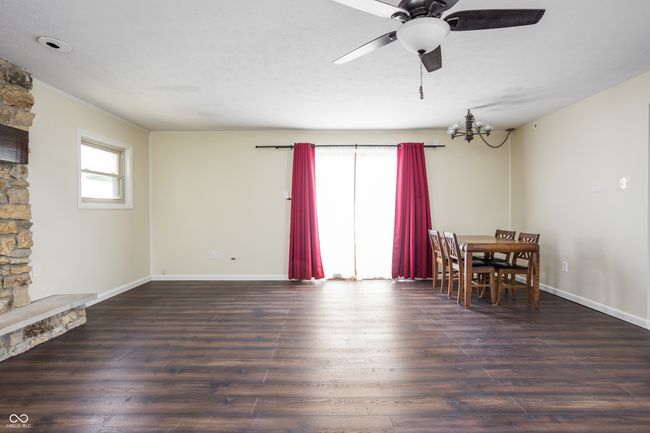 dining room featuring wood finished floors, plenty of natural light, a chandelier, and ceiling fan | Image 11