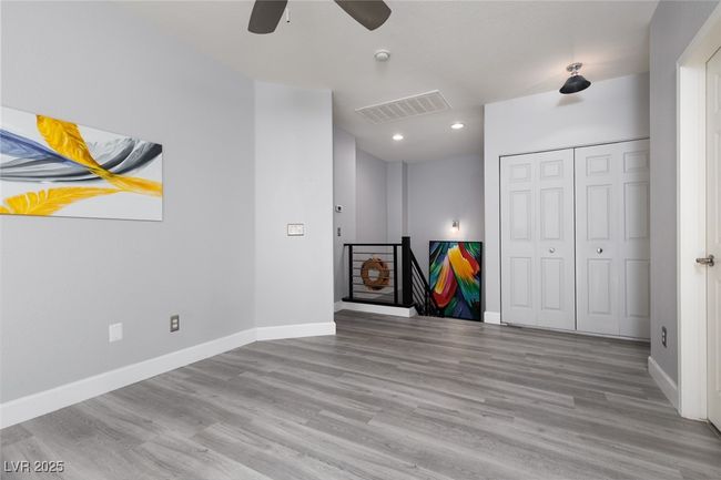 Unfurnished living room with ceiling fan, baseboards, wood finished floors, and visible vents | Image 13
