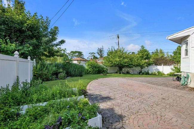 Fenced backyard with a patio | Image 16
