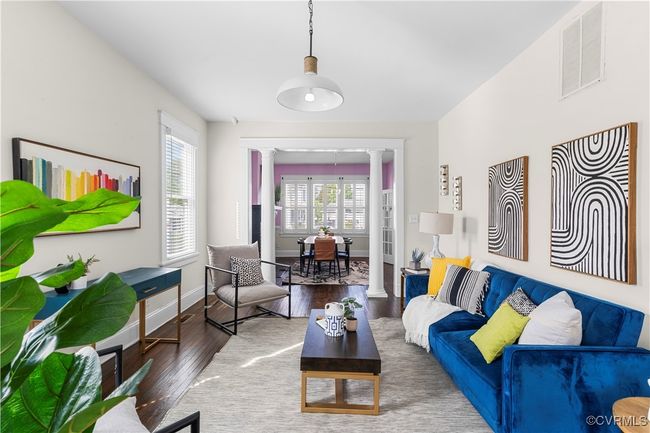 Living room featuring wood finished floors, visible vents, baseboards, and decorative columns | Image 12