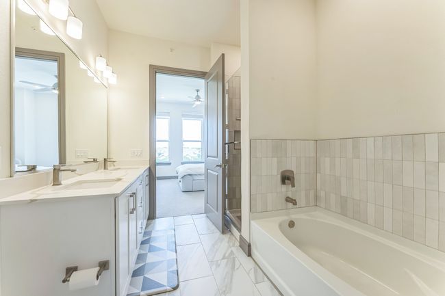 Bathroom featuring ceiling fan, a garden tub, double vanity, and ensuite bath | Image 20