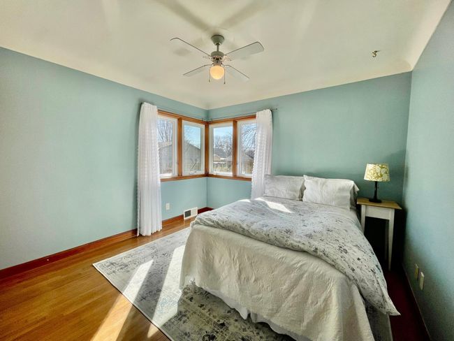 The main floor second bedroom enjoys plenty of natural light from the two corner windows. | Image 10