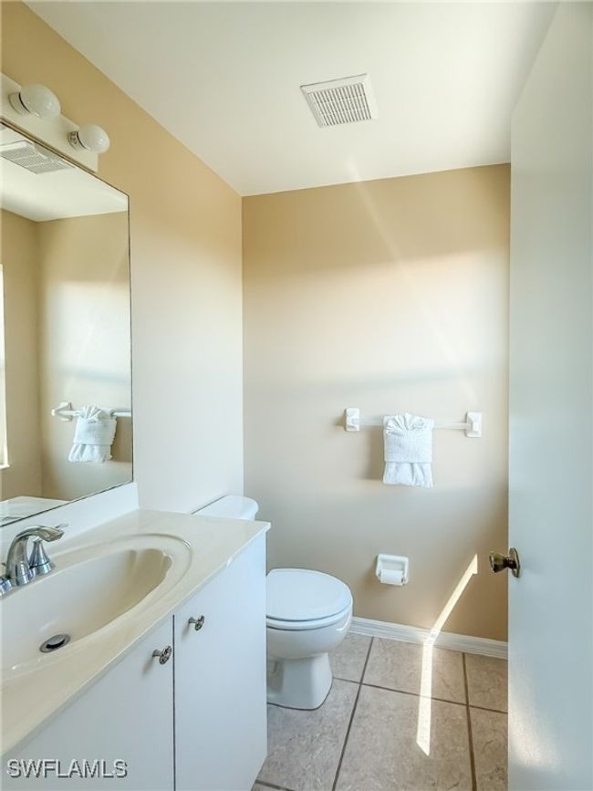 Bathroom with toilet, vanity, tile patterned flooring, and visible vents | Image 24