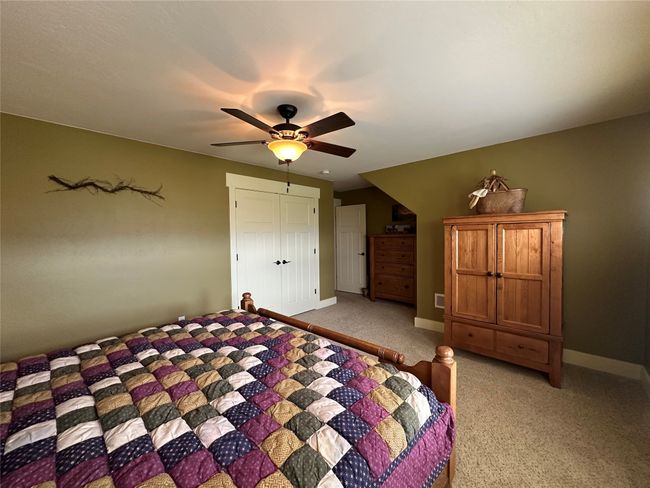 Bedroom featuring light colored carpet, ceiling fan, and a closet | Image 19