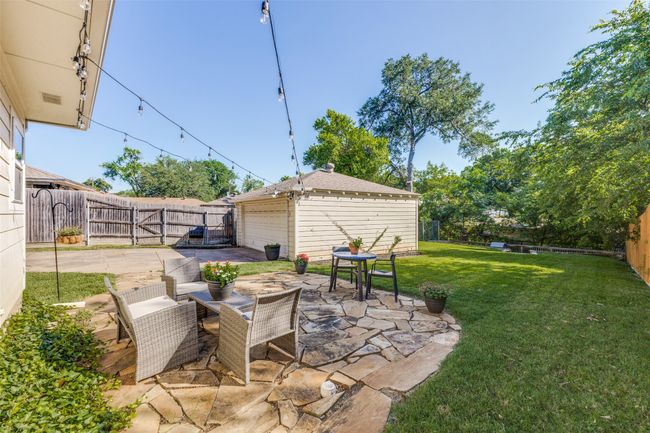 Fenced backyard featuring a garage & patio area | Image 23