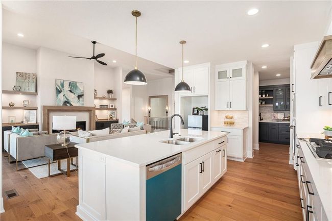 Kitchen with dishwasher, light wood-style floors, custom exhaust hood, a ceiling fan, and decorative backsplash | Image 10