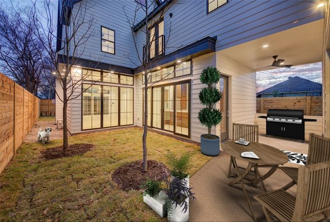 Virtually staged. 1 of 2 yard areas that connects the kitchen, dining, patio and climate controlled garage/flex room. The patio is plumbed for natural gas to set up your grill or create the outdoor kitchen of your dreams. Newly planted pecan trees could be easily relocated to accommodate an oversized deck and/or plunge pool. | Image 8
