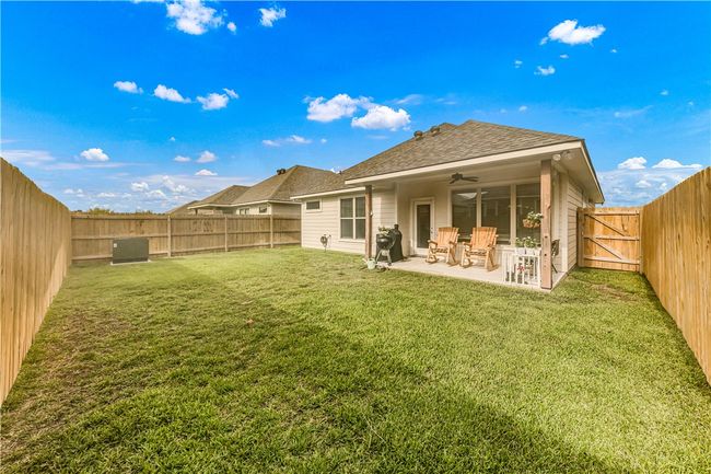 Back of house with a ceiling fan, a fenced backyard, a patio, roof with shingles, and a gate | Image 15