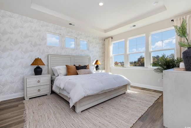 Bedroom with wallpapered walls, baseboards, a tray ceiling, wood finished floors, and recessed lighting | Image 23