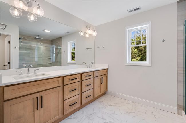 Full bath with marble finish floor, double vanity, baseboards, and a sink | Image 23