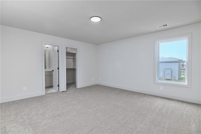 Unfurnished bedroom with ensuite bath, light colored carpet, and a spacious closet | Image 36