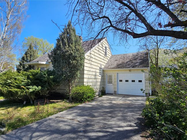 View of side of property featuring driveway, roof with shingles, and a garage | Image 27