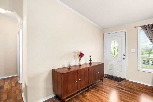 Entryway with crown molding, baseboards, and wood finished floors | Image 5