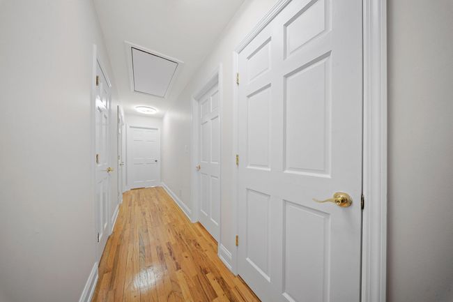 Corridor with attic access, baseboards, and light wood finished floors | Image 11