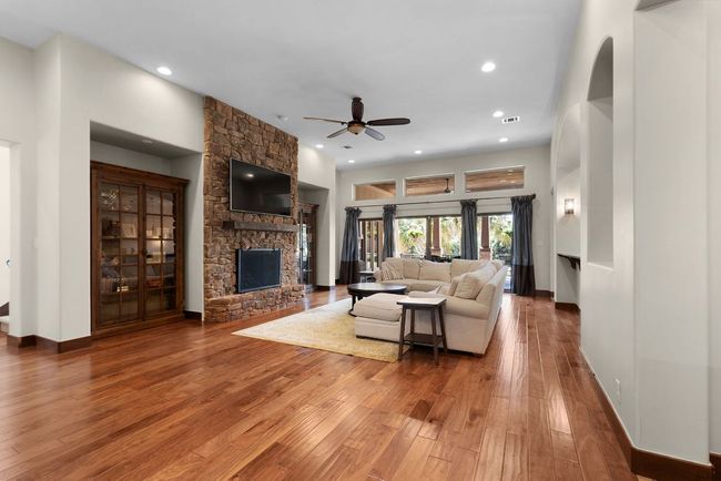 Living room with a ceiling fan, a fireplace, hardwood / wood-style flooring, recessed lighting | Image 11
