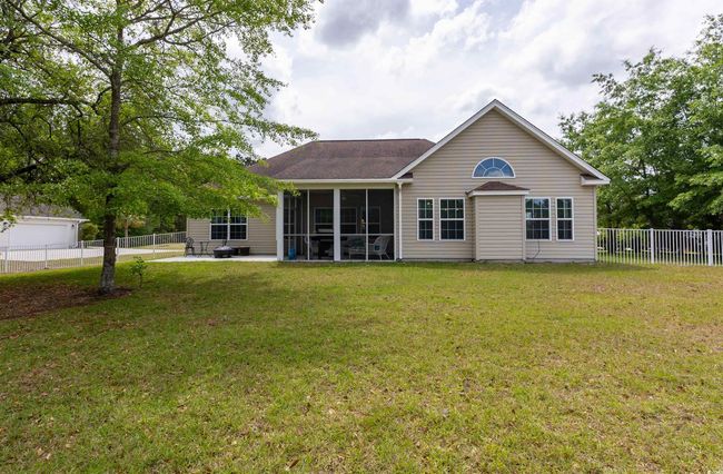 Rear view of property featuring a lawn, a sunroom, a patio area, and a fenced backyard | Image 29