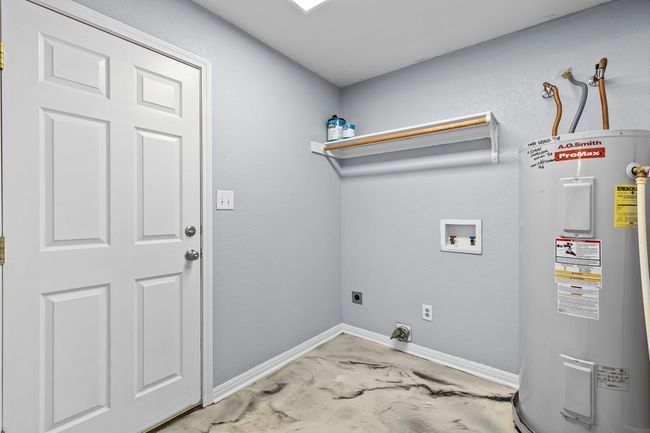 Laundry room featuring hookup for an electric dryer, electric water heater, and washer hookup | Image 23