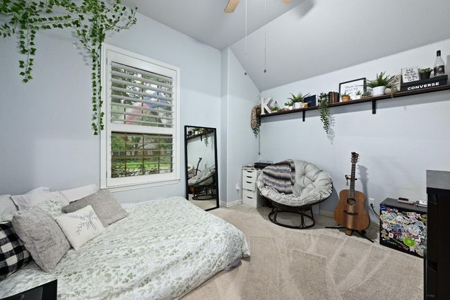 Carpeted bedroom with vaulted ceiling and a ceiling fan | Image 23