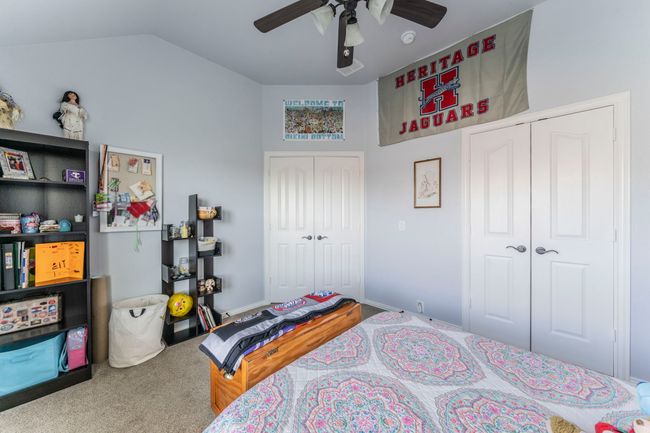 Bedroom with carpet flooring, ceiling fan, and lofted ceiling | Image 17