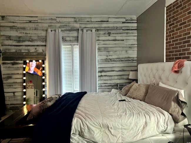 Bedroom featuring ornamental molding and brick wall | Image 15