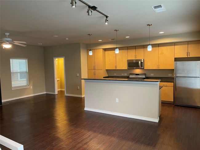 Kitchen featuring appliances with stainless steel finishes, dark countertops, dark wood-style flooring, recessed lighting, and ceiling fan | Image 14