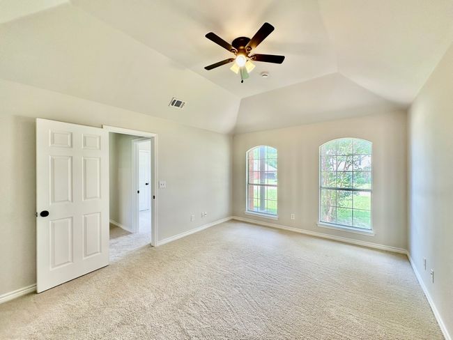 Carpeted spare room featuring a ceiling fan and lofted ceiling | Image 9