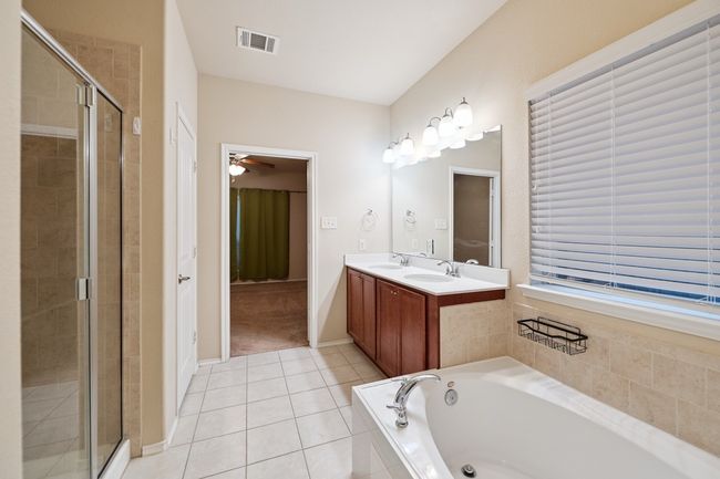 Bathroom featuring a shower stall, a garden tub, double vanity, and tile patterned floors | Image 27