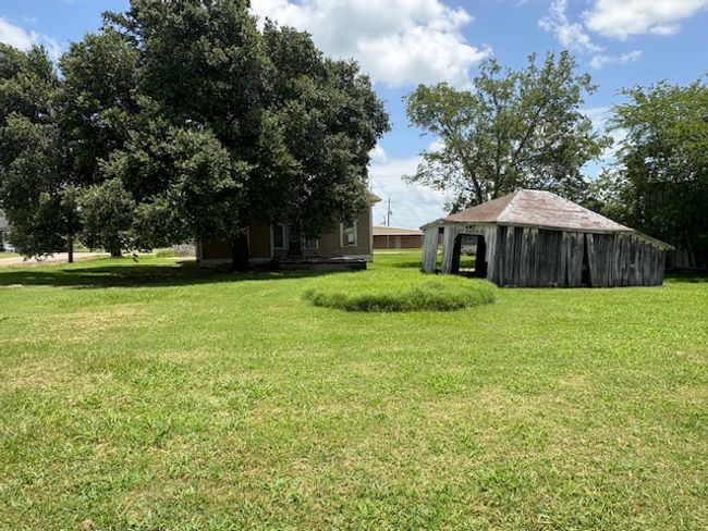 View of grassy yard with a pole building and an outdoor structure | Image 8