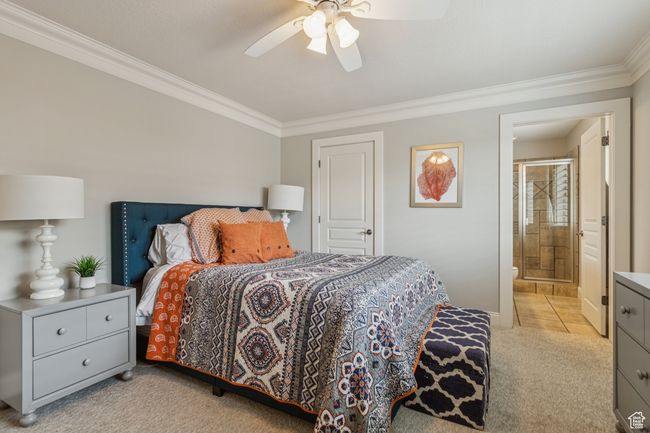 Bedroom with ornamental molding, light carpet, connected bathroom, and ceiling fan | Image 49